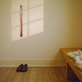 Oak & Ease magnetic wooden shoehorn on its wall mount in a sunlit Scandinavian entryway